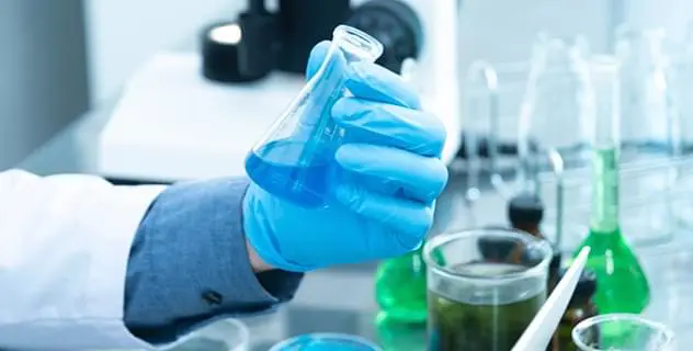 Profissional de saúde manuseando vidrarias de laboratório para o guia de abertura de novas farmácias.